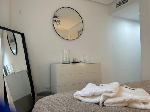 ein Schlafzimmer mit einem Bett mit einem Spiegel und einer Kommode in der Unterkunft Fantastic Two Bedroom Apartment in Málaga