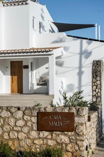 a sign in front of a white house at Casa Malìa Luxury Guest House in Luz