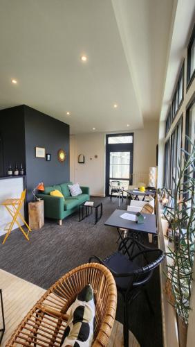 un salon avec un canapé vert et des tables dans l'établissement Hotel de France, à Saint-Pol-de-Léon