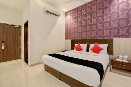 1 dormitorio con 1 cama grande con almohadas rojas en S B Excellency, en Jodhpur
