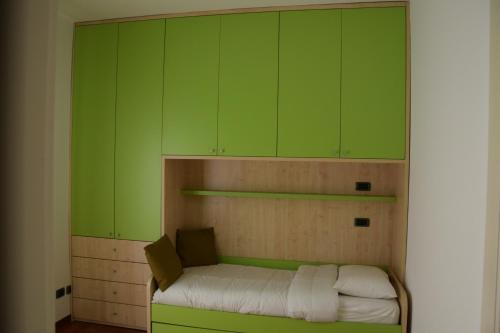 a room with green cabinets and a small bed at Mocenigo4 in Milan