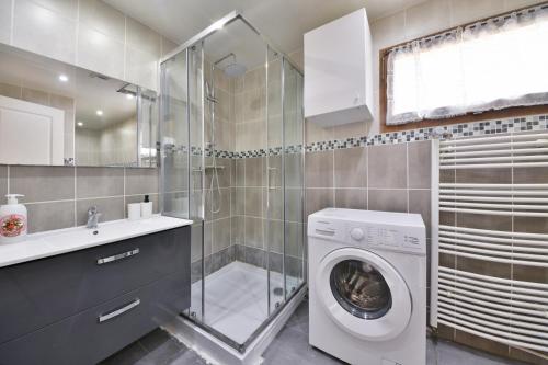 La salle de bains est pourvue d'un lave-linge et d'une douche. dans l'établissement Pleasant Appartment near Stade de France, à Saint-Denis