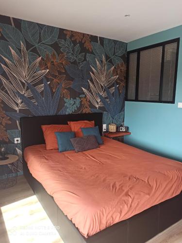 - une chambre dotée d'un grand lit avec des draps orange dans l'établissement LE DOUX REFUGE, à Orchaise