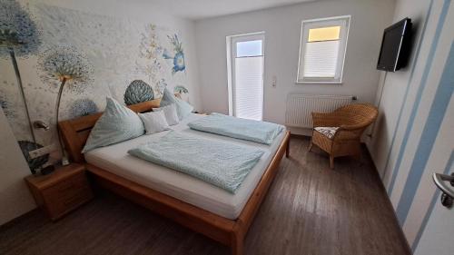 1 dormitorio pequeño con 1 cama y 1 silla en Ferienwohnung PUNKT, 5 Gehminuten vom Europa-Park, en Rust