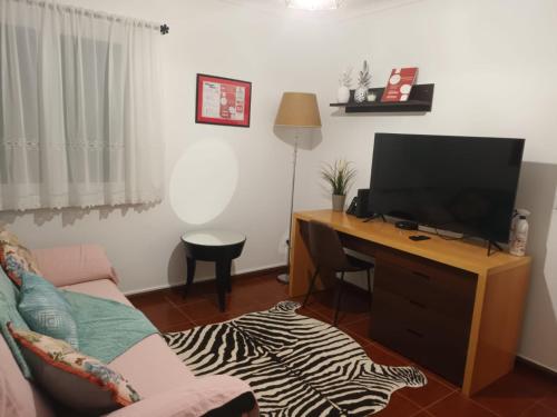 a living room with a television on a wooden desk at Casa Miradouro in Ribeira Grande