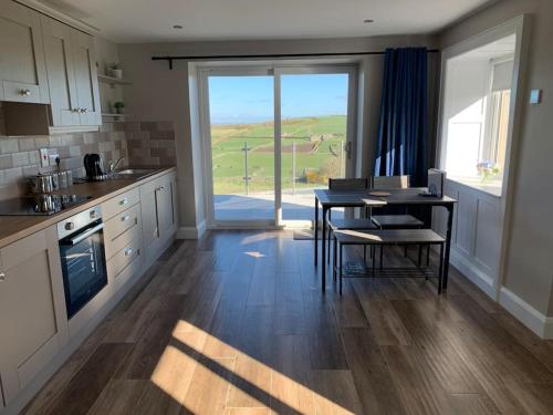 a kitchen with a table and a dining room at Betty's Cottage in Newcastle