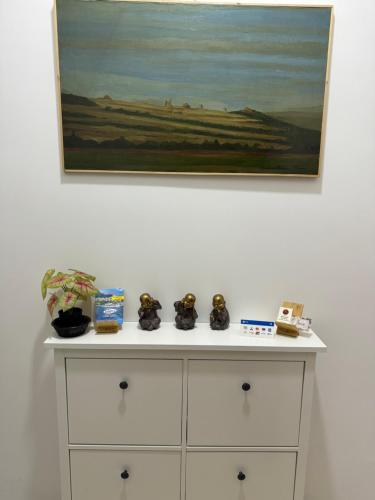 a white dresser with a painting on the wall at STELLA MARIUS in Salerno