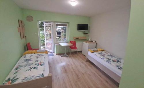 a bedroom with two beds and a desk and a window at Noclegi Julia pokoje 1-3 parter Chodkiewicza śniadanie kontynentalne in Kielce