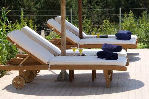 a group of lounge chairs sitting on a patio at Kefalonia Horizon Villas in Ayia Evfimia