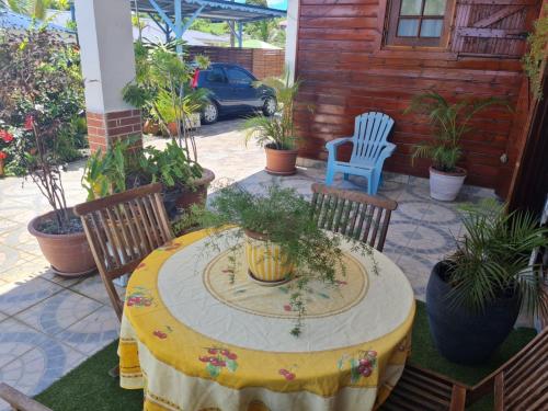a table and chairs on a patio with plants at La maison de campagne in Morne-à-lʼEau