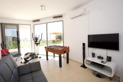 a living room with a couch and a table with a chessboard at Kefalonia Horizon Villas in Ayia Evfimia
