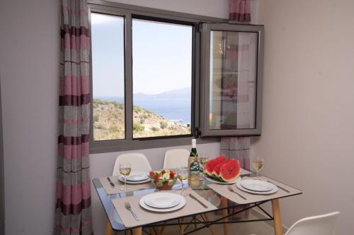 a table and chairs with a table and a window at Kefalonia Horizon Villas in Ayia Evfimia