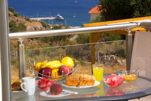 a table with a bowl of fruit and a bowl of bread at Kefalonia Horizon Villas in Ayia Evfimia