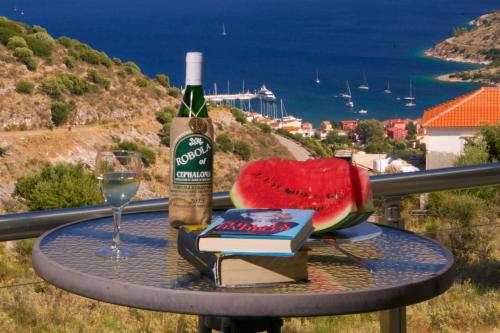 a table with a bottle of wine and a glass at Kefalonia Horizon Villas in Ayia Evfimia