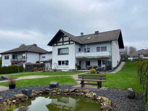 a house with a pond in front of a house at Fewo Burgwald in Industriehof