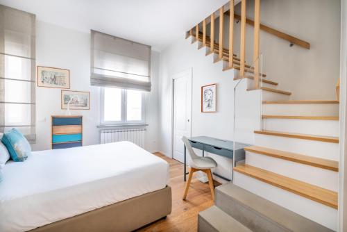 ein Schlafzimmer mit einem Bett und einem Schreibtisch neben einer Treppe in der Unterkunft Top Floor Apt with Rooftop Terrace near St. Peter in Rom