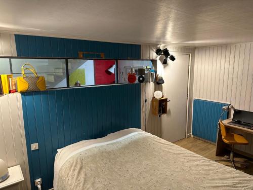 Cette chambre comprend un lit et un mur bleu. dans l'établissement Grand gîte - avec grande piscine - au calme, à Charron