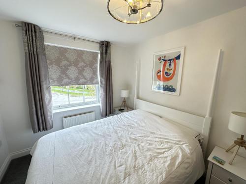 a bedroom with a white bed and a window at Arthurs Escape in Filey