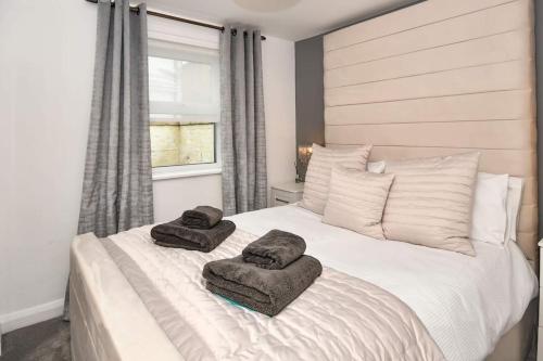 a bedroom with a white bed with towels on it at The Hideaway - Luxury 2 bedroom ground floor apt in Warkworth