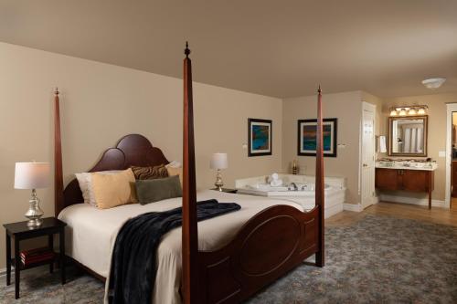 a bedroom with a large bed and a bath tub at The Oakwood Inn in Okoboji