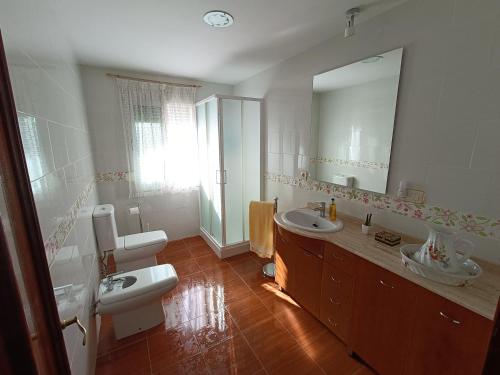 a bathroom with two sinks and a large mirror at Mi Carmela in Cenes de la Vega