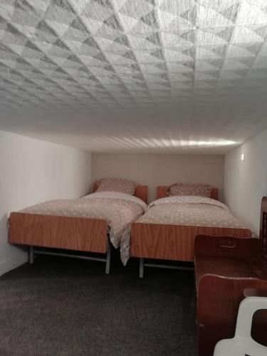 deux lits dans une chambre avec un plafond dans l'établissement Appartement rez-de-chaussée, à Sainte-Cécile-Plage