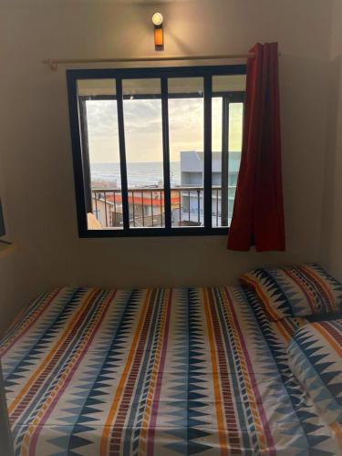 - une chambre avec un lit en face d'une fenêtre dans l'établissement Studio des vagues, à Lacanau