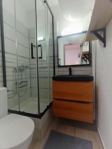 a bathroom with a glass shower and a sink at Studio des vagues in Lacanau