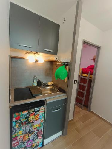 une cuisine avec un évier et un plan de travail dans l'établissement Studio des vagues, à Lacanau