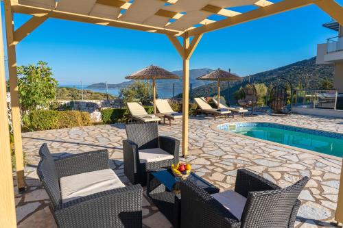 a patio with chairs and a pool with a view at Kefalonia Horizon Villas in Ayia Evfimia