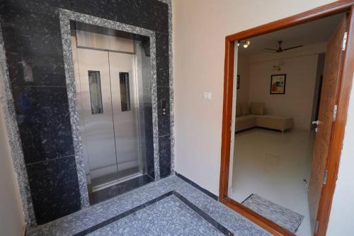 a mirror in a room with a door and a living room at 2.Chez Moi - 2BHK, Gachibowli in Hyderabad