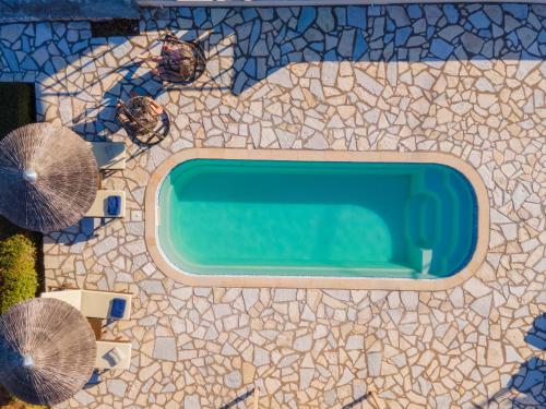 an overhead view of a swimming pool with two umbrellas at Kefalonia Horizon Villas in Ayia Evfimia