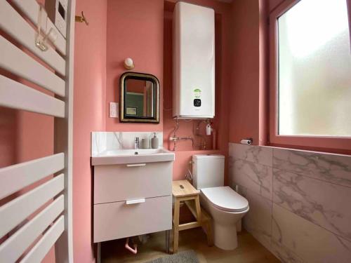uma casa de banho com um lavatório, um WC e uma janela. em Superbe appartement avec chambre, proche plage em Le Touquet-Paris-Plage