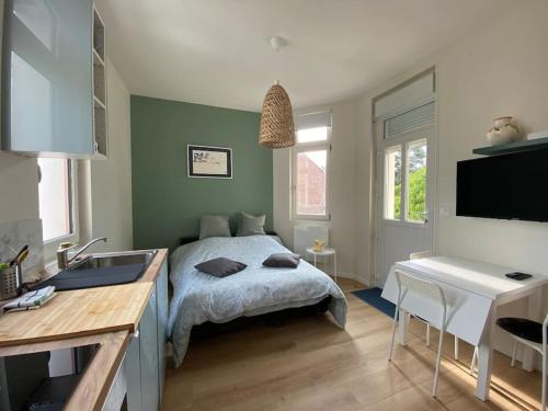 1 dormitorio con 1 cama y lavamanos. en Superbe appartement avec chambre, proche plage, en Le Touquet-Paris-Plage