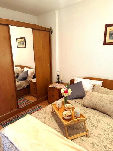 a bedroom with a bed and a table and a mirror at Stan na dan Kej Una in Bosanska Dubica