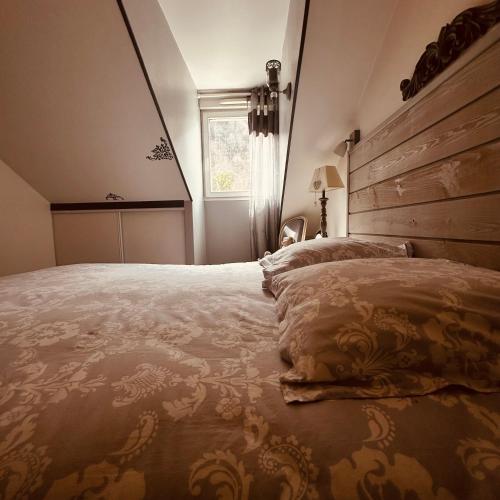 une chambre avec un grand lit avec une tête de lit en bois dans l'établissement Le NID DES BAINS, à Luchon