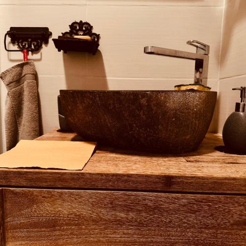 La salle de bains est pourvue d'un lavabo en pierre sur un comptoir. dans l'établissement Le NID DES BAINS, à Luchon