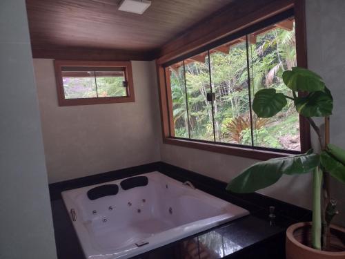 a bath tub in a bathroom with a window at Sítio Cachoeirinha in Marechal Floriano