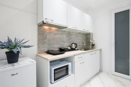 a white kitchen with a sink and a microwave at Supreme Aprt Syntagma Kolonaki in Athens