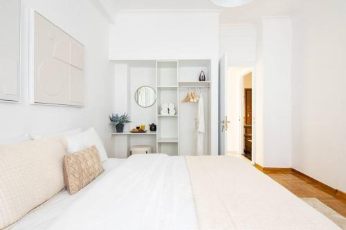 a white bedroom with a large white bed at Supreme Aprt Syntagma Kolonaki in Athens