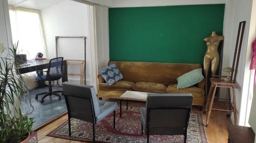 a living room with a couch and a green wall at En el corazón de Palermo Soho in Buenos Aires