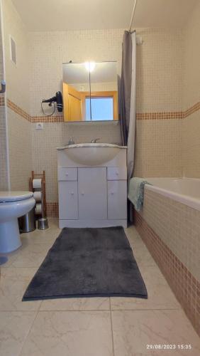 een badkamer met een wastafel, een bad en een spiegel bij Aldea beach 3 in Manilva