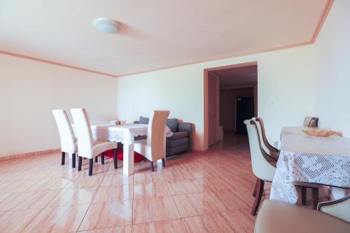 a dining room with a table and chairs and a couch at Casa Iulia in Haţeg