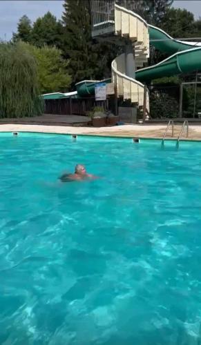 un homme nageant dans une piscine dans l'établissement Le chalet de DOMY, à Granges-sur-Vologne