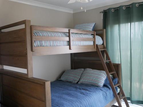 a bedroom with a bunk bed with a blue bedsheet at Beach Star Villa in North Topsail Beach