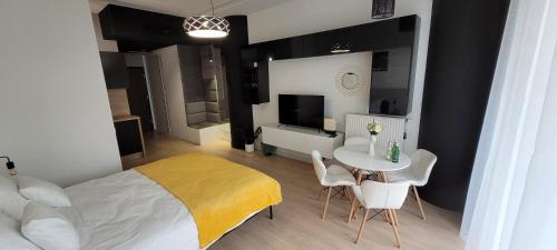 a bedroom with a bed and a table with chairs at Hanza Tower Apartament 306, BASEN, SAUNA, JACUZZI in Szczecin