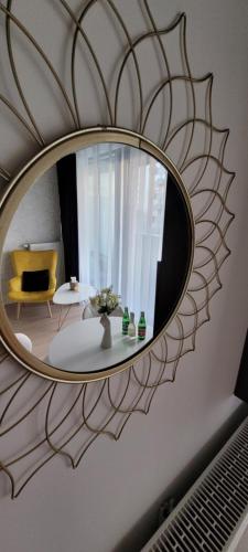 a mirror on a wall with a table and a chair at Hanza Tower Apartament 306, BASEN, SAUNA, JACUZZI in Szczecin