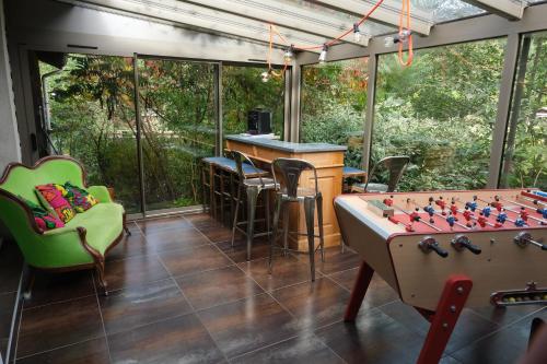 a screened in porch with a pool table and a bar at Gîte du ruisseau in Épinal