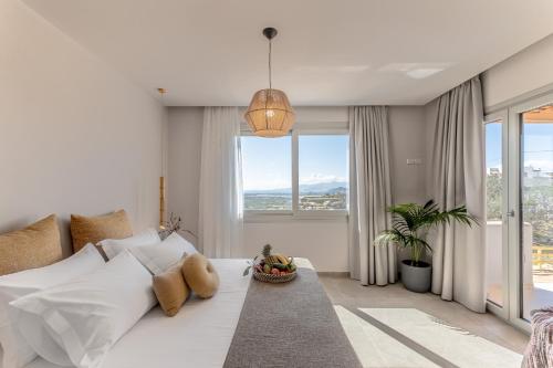 - une chambre blanche avec un lit et une grande fenêtre dans l'établissement Eartha Horizon Villas, à Naxos Chora