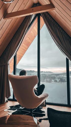 a room with a chair in front of a large window at VILLA TEDDY BEAR Zakopane in Zakopane